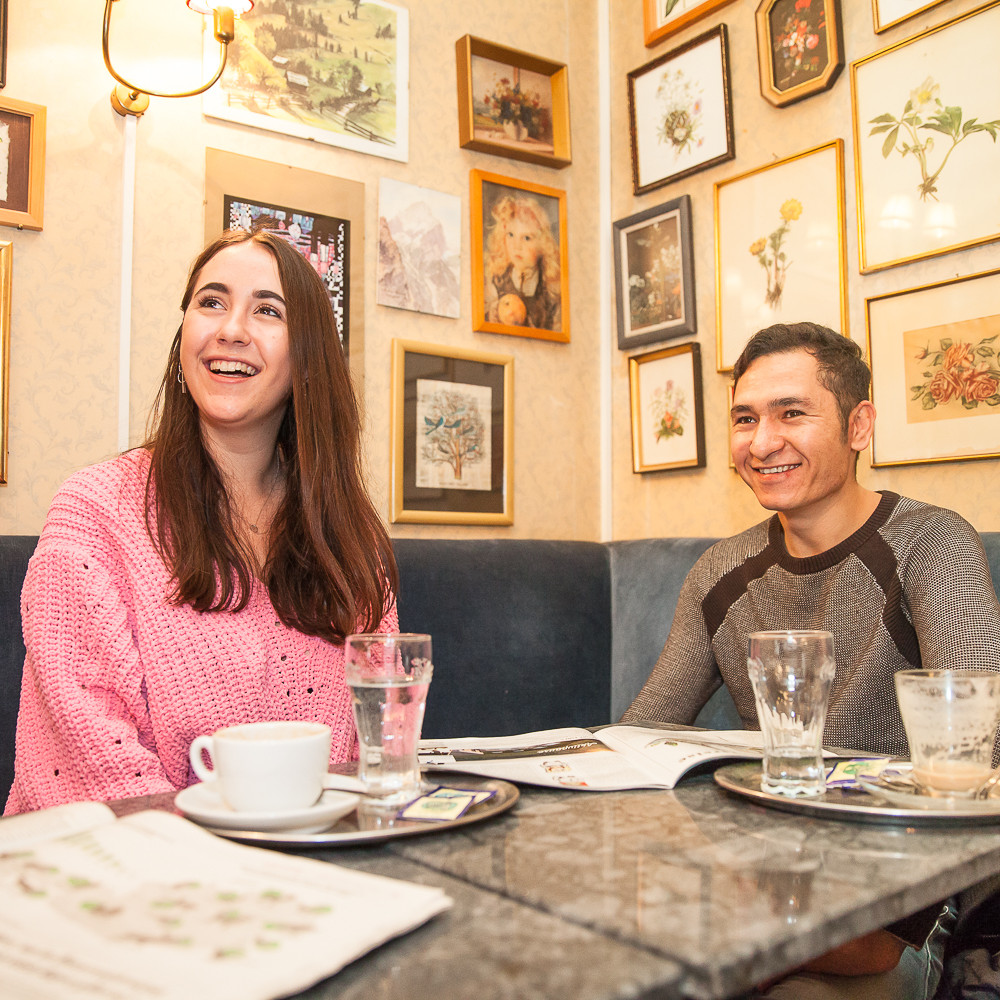Ein junger Mann und eine junge Frau im Kaffeehaus.