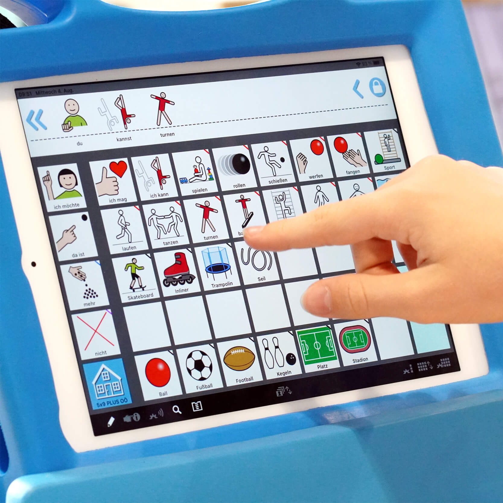 Ein Mädchen wählt auf einem Tablet Symbole aus und bildet so einen Satz: Du kannst turnen.