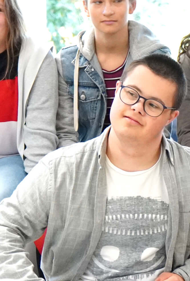 Diakonie-Direktorin Maria Katharina Moser im Publikum einer Schulklasse bei einer Schulaufführung.
