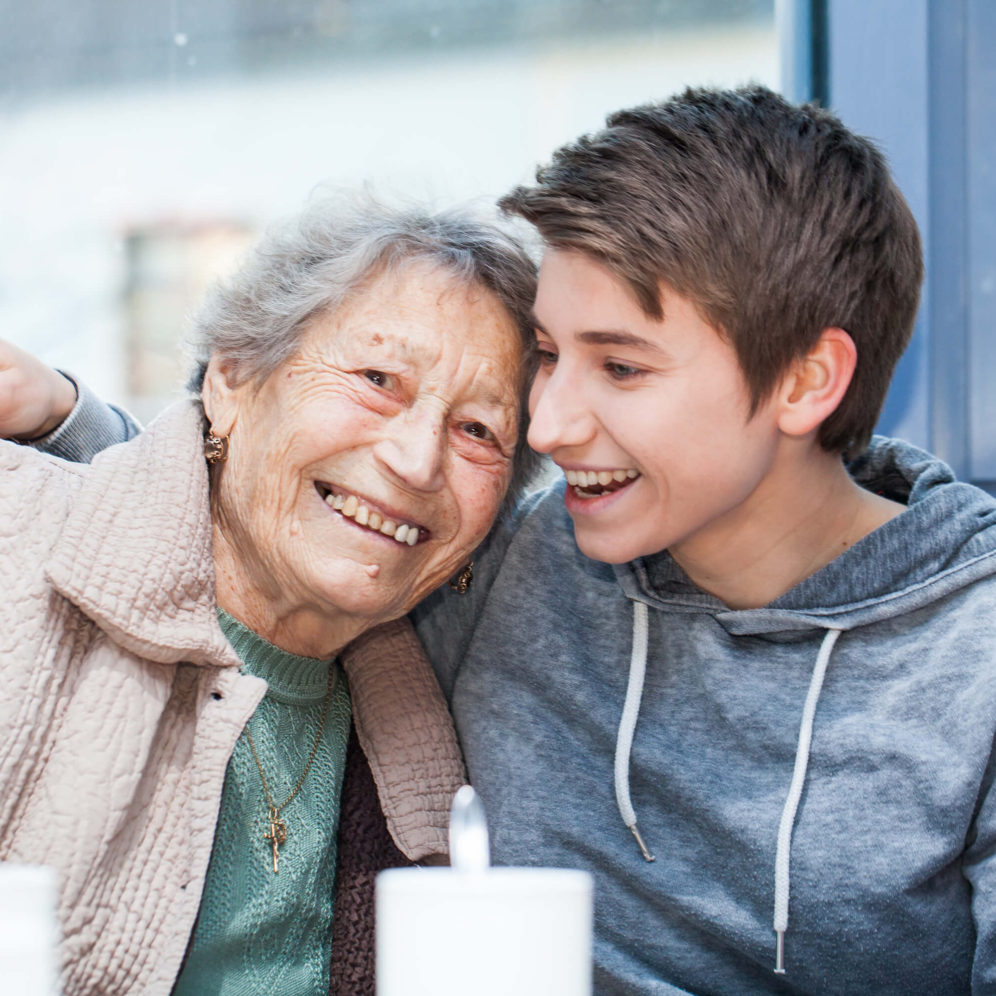 Eine ältere Frau und Enkelkind lachen gemeinsam.