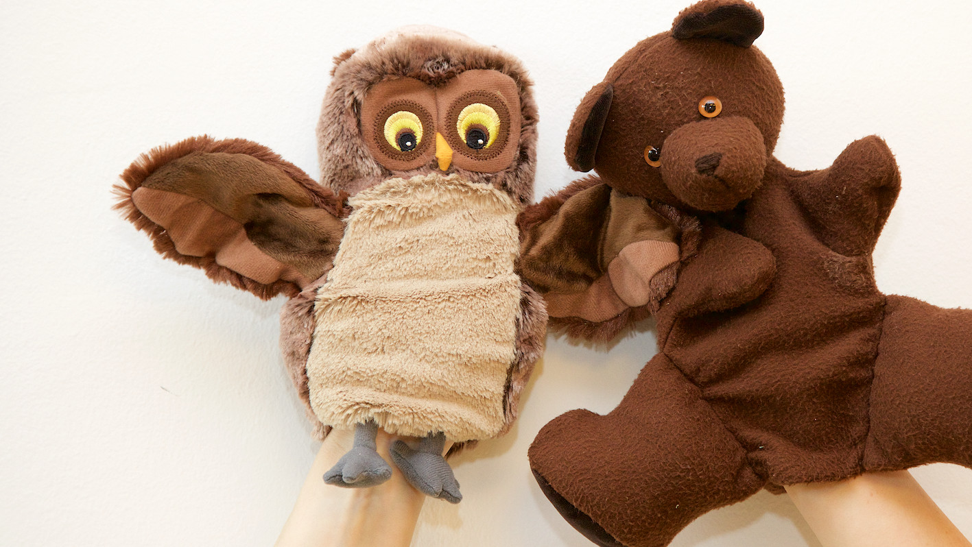 Eine Eulen-Handpuppe und eine Teddybär-Handpuppe wirken traurig