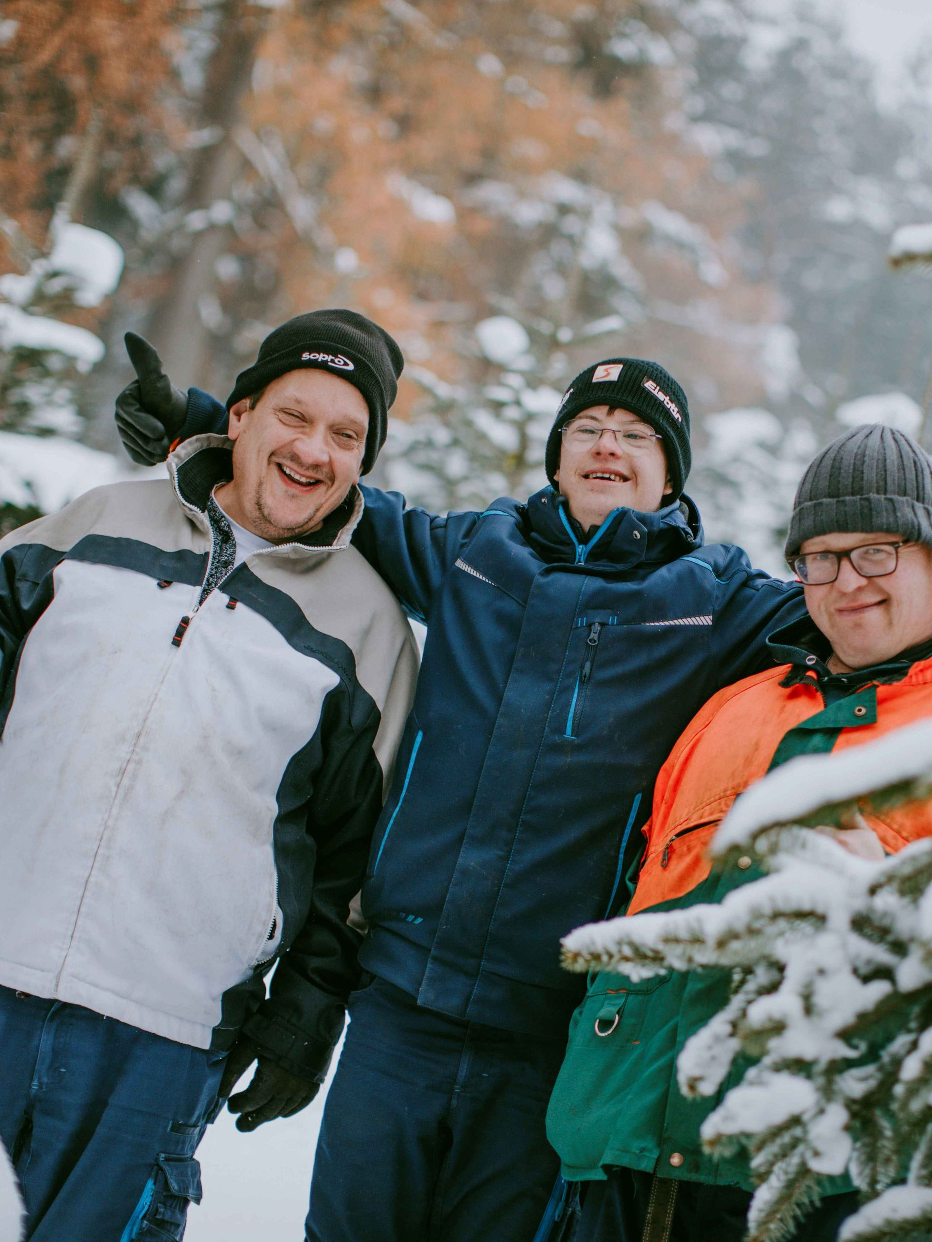 Drei Mitarbeiter im verschneiten Weihnachtswald von Garten & Landschaft