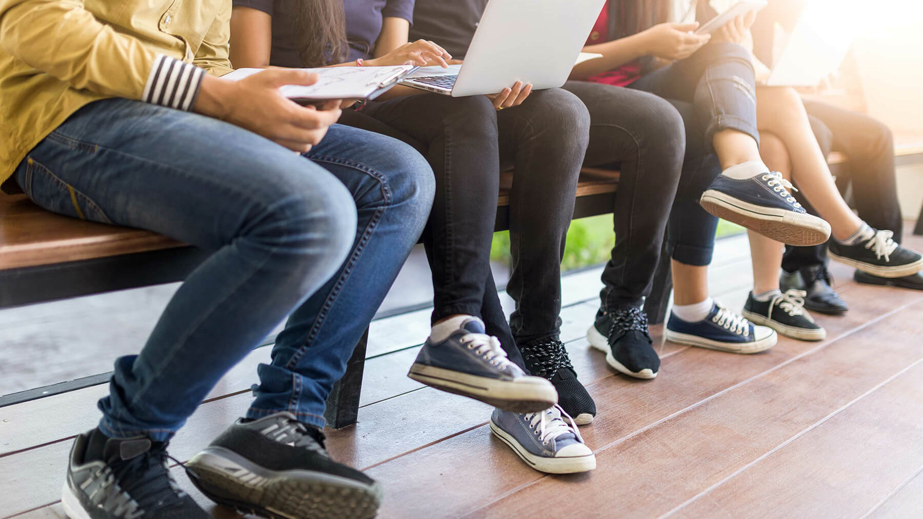 Mehrere Schüler:innen auf einer Bank.