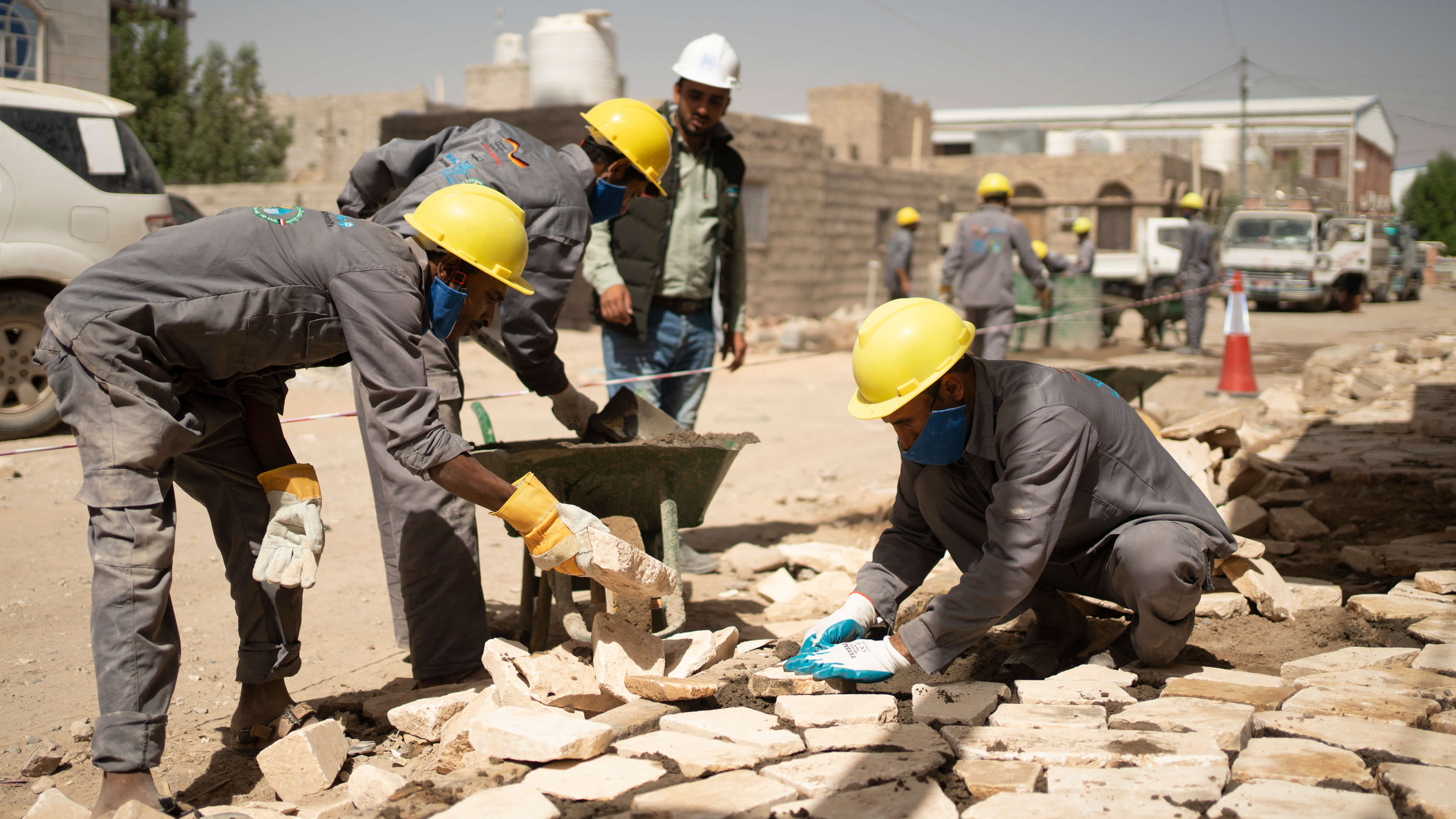Ein paar Arbeiter beim Wiederaufbau von gemeinschaftlich genutzten Infrastrukturen.