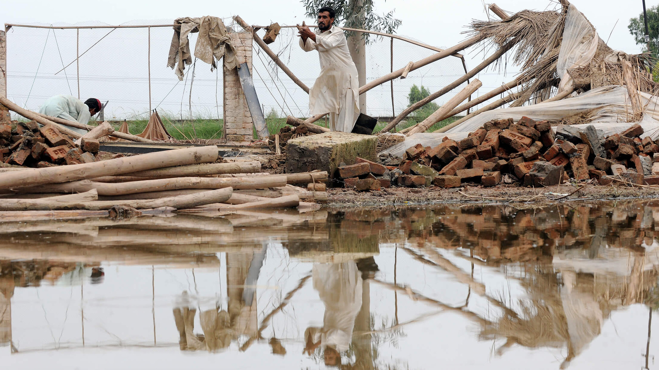 Meschen, Holz und Wasser bei einem Unwetterkatastrophe in Pakistan